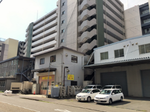 黄色い看板の建物が当院です